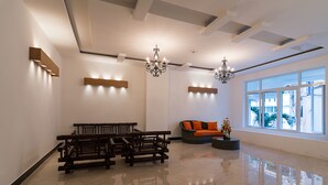 A spacious lobby with a polished floor, a wooden bench, a cushioned sofa, and a chandelier. - Veevoo Hotel (Ho Chi Minh City)