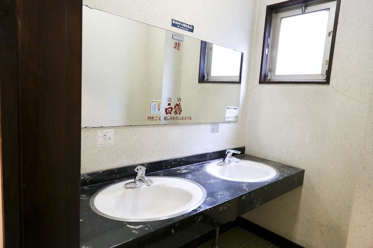 A bathroom with two sinks, a mirror, and a window.