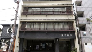 A two-story building with a dark entrance and signage in Japanese. - Guest House Route53 Furuichi (Nara)