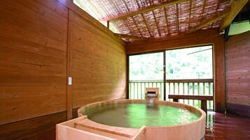 A wooden spa room with a hot tub and a wooden bench.