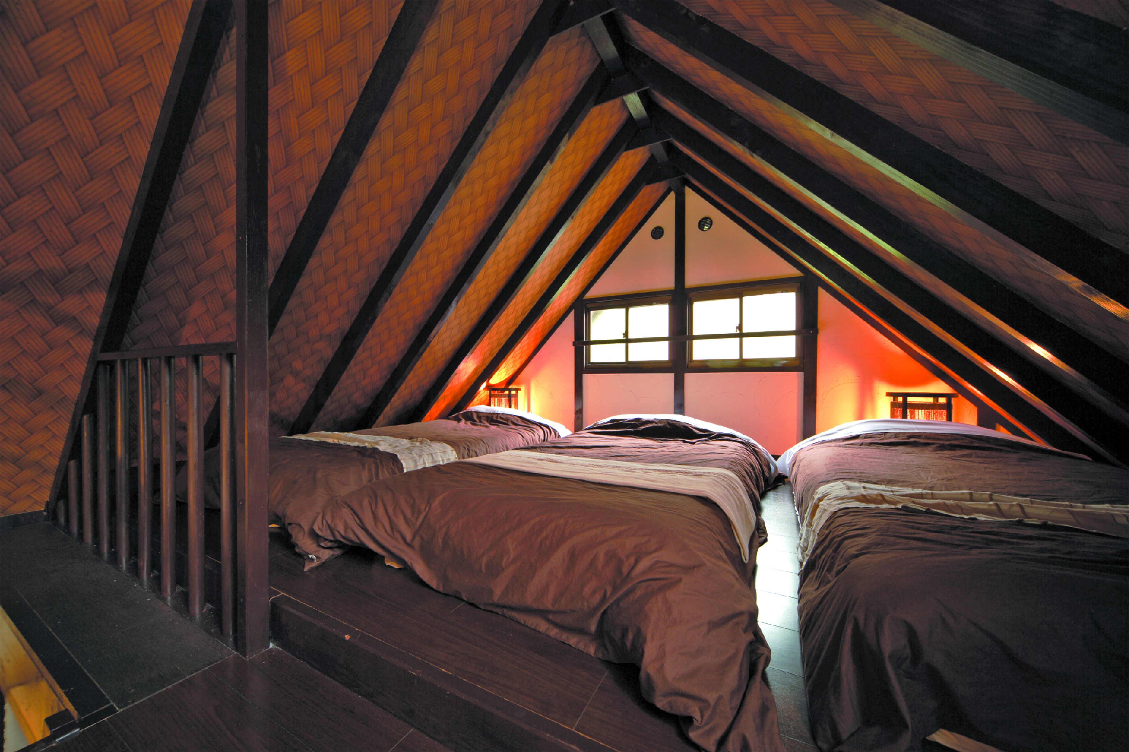 Une chambre avec deux lits, des poutres en bois et une fenêtre donnant sur un beau paysage.
