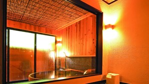 Un cuarto de spa con un amplio ventanal, techo de madera y piso de mármol.