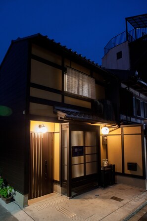 Vista frontal de la propiedad por la tarde o noche