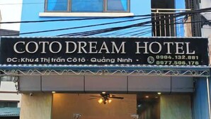 A blue hotel building with a sign reading 'COTODREAM HOTEL' and contact information. - Coto Dream Hotel (Co To)