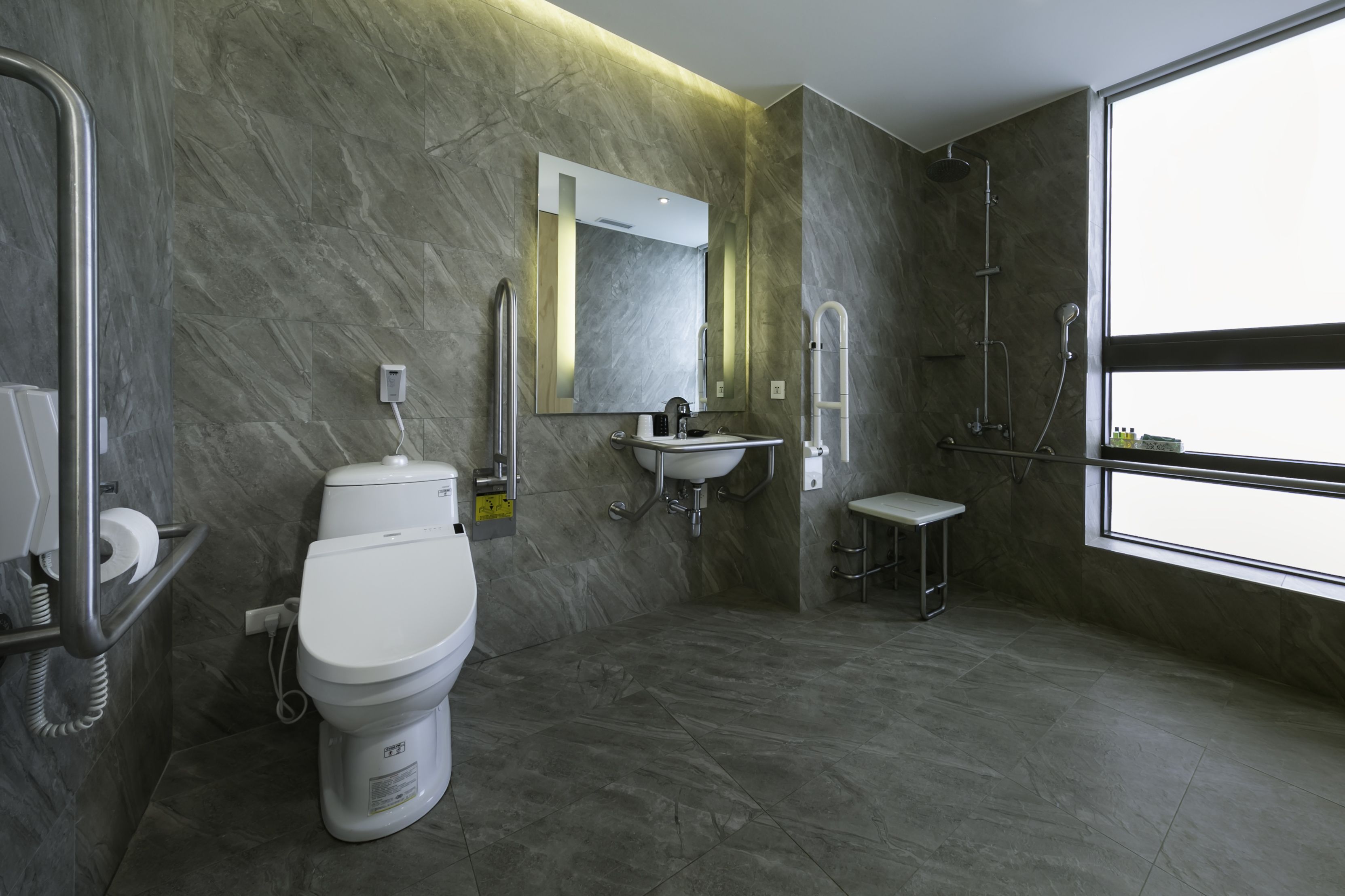 A modern bathroom with a toilet, sink, and shower.