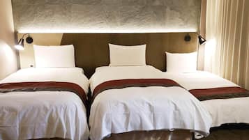 Habitación de hotel con dos camas, cada una con ropa blanca y detalles en marrón.