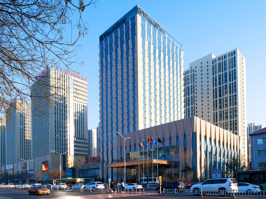 A modern building with a glass facade and a prominent entrance.