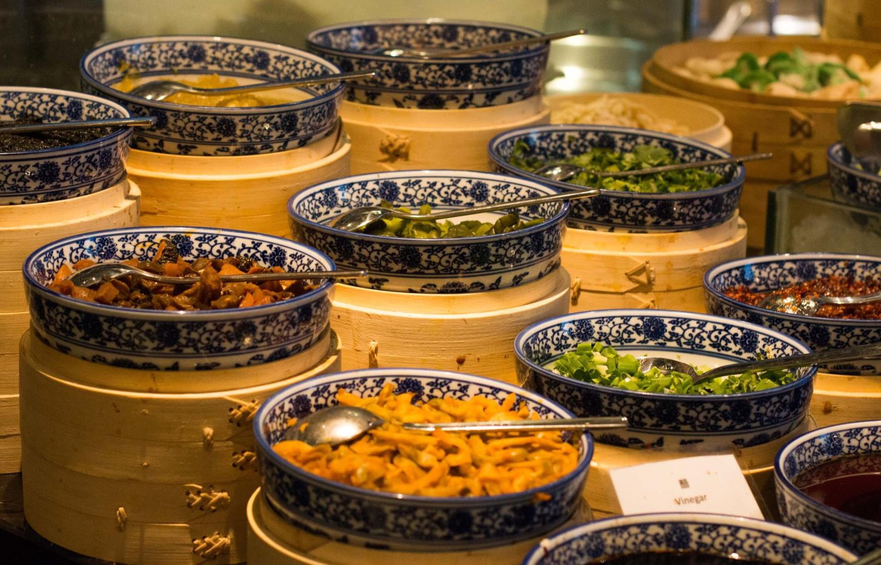 A buffet with various dishes in blue and white patterned bowls.