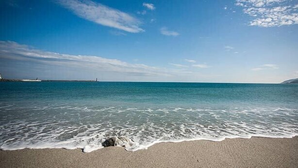 Una playa con aguas azul turquesa y una orilla arenosa.