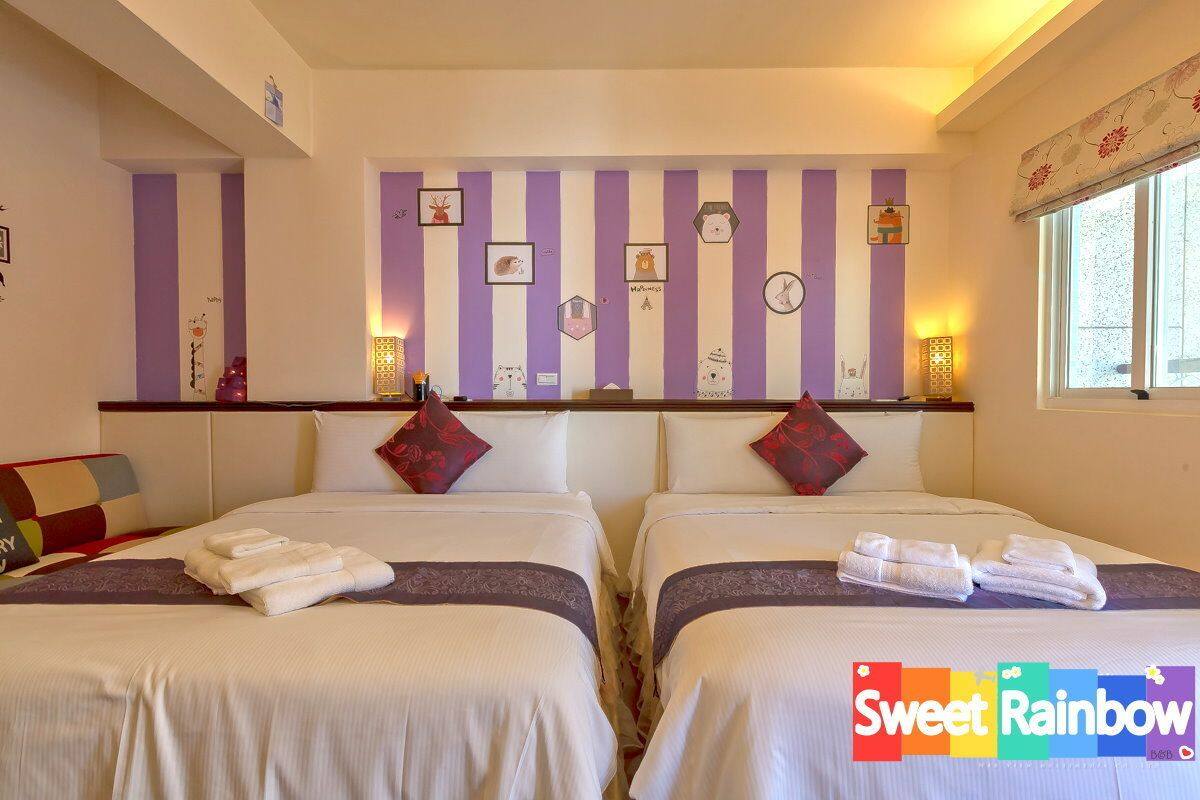 A hotel room with two beds, striped wall decor, and a window with curtains.