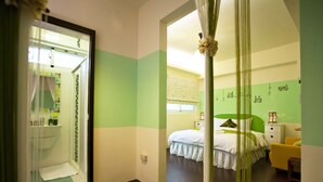 Una habitación de hotel con cama, mesita de noche y un pequeño rincón de descanso.