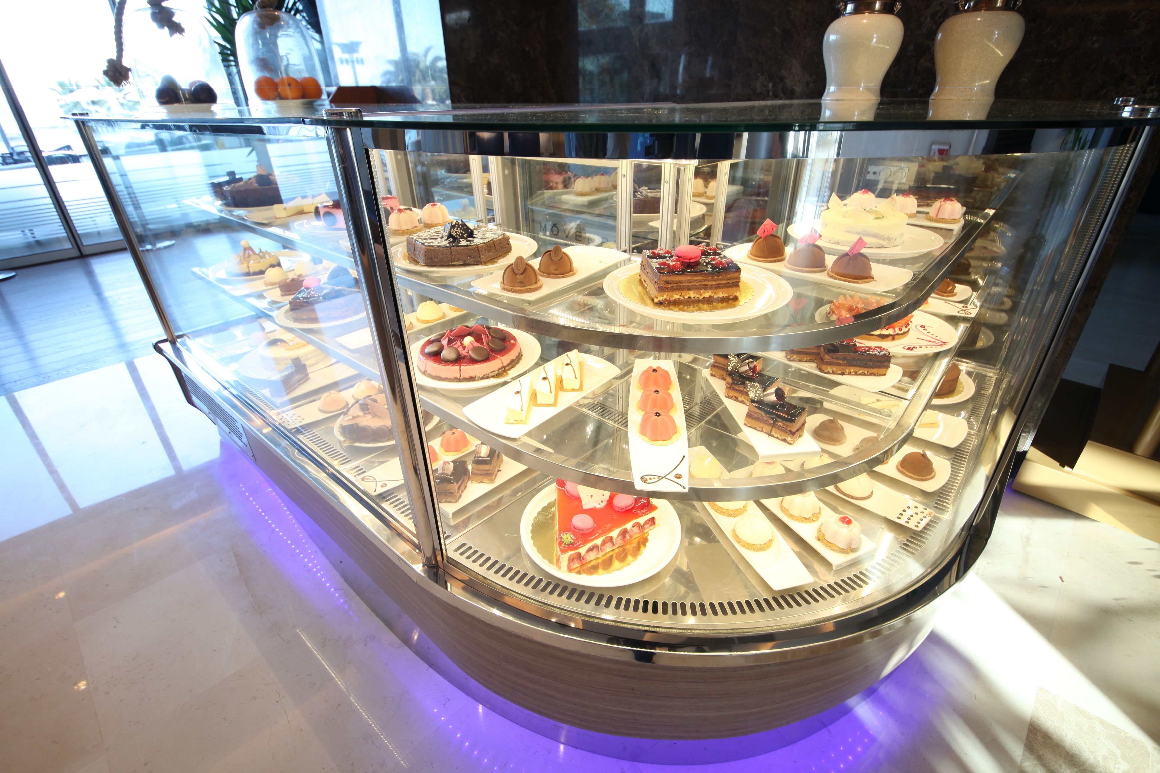 A dessert display case with various cakes and pastries.