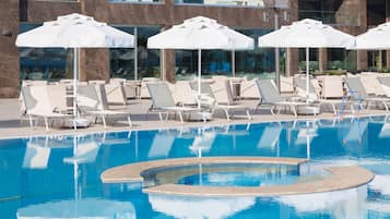 Piscine couverte, piscine extérieure, parasols de plage, chaises longues