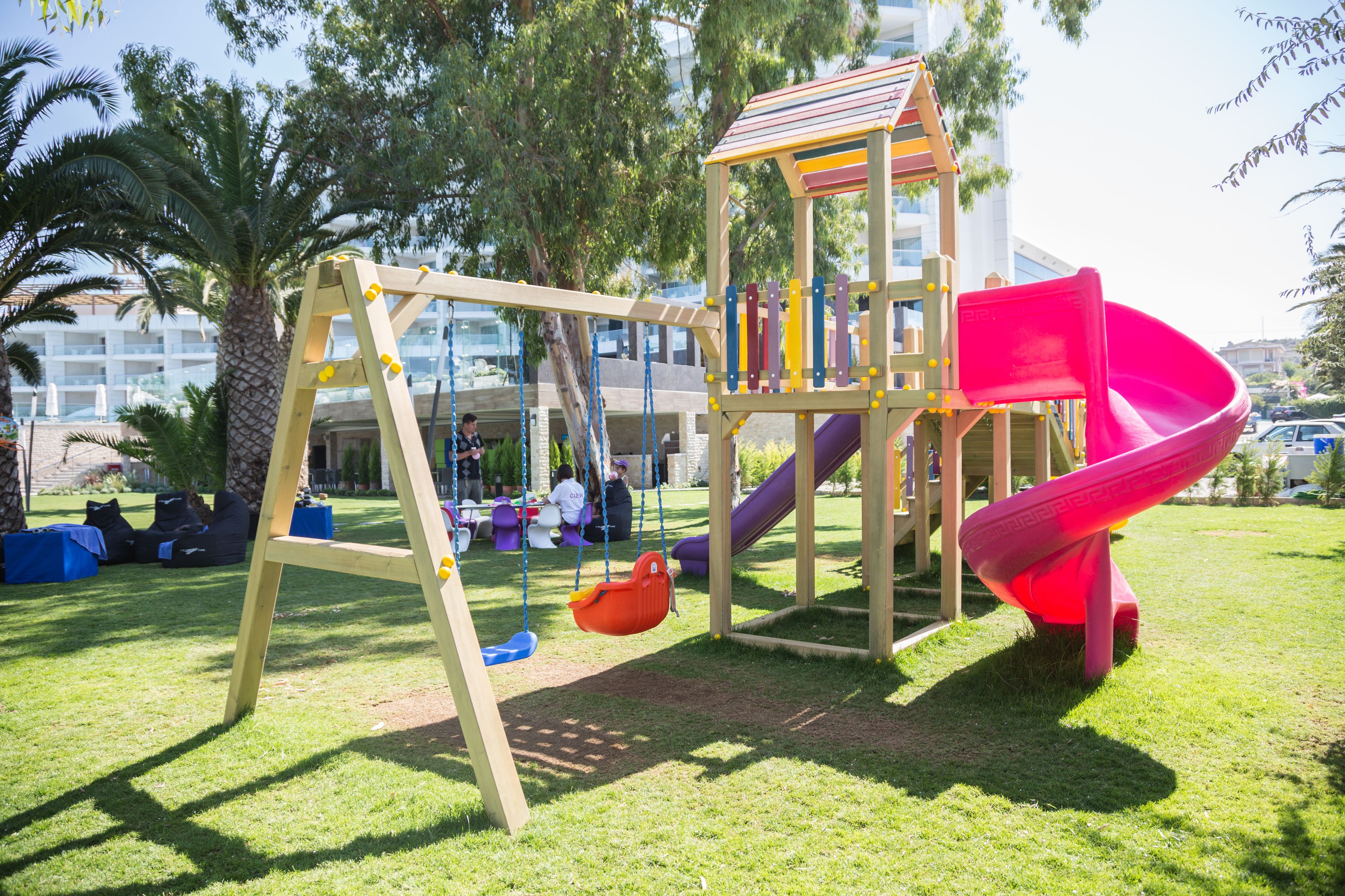 A playground with a swing set, a slide, and a climbing structure.