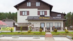 A two-story building with a sign reading "MINI-OTEHL PLE MENSKA RESTORAR."