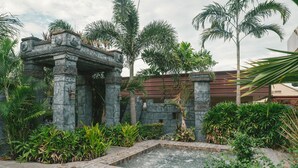 A stone structure with a water feature and tropical plants. - Cebu Westown Lagoon - South Wing (Mandaue)