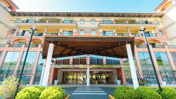 A hotel entrance with a covered walkway, large windows, and a central entrance.