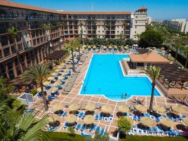 Una piscina cubierta, una piscina al aire libre, tumbonas