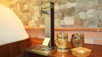 A bar area with a beer tap, two wooden mugs, and a wooden coaster.