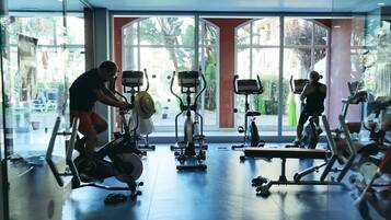 A gym with stationary bikes, a treadmill, and exercise equipment.