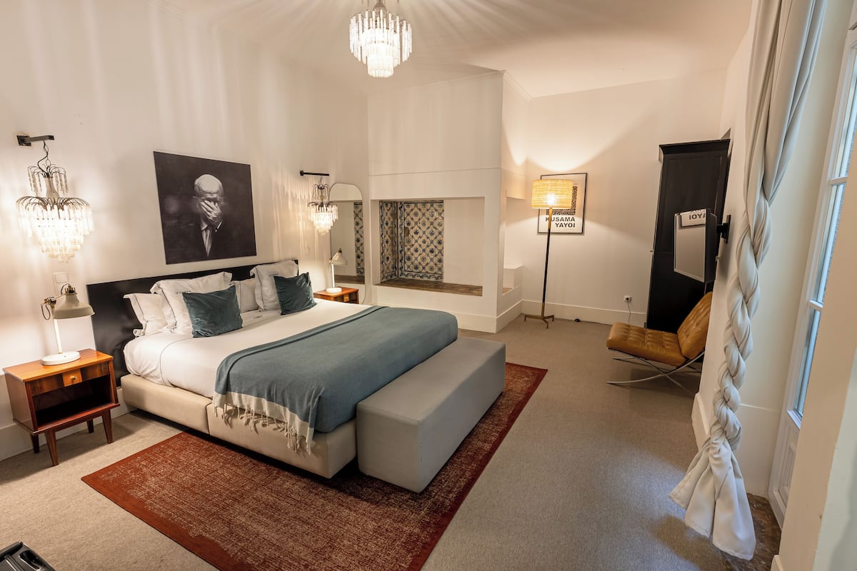 Un dormitorio moderno con una cama grande, lámparas de noche, un espejo y vistas al exterior.