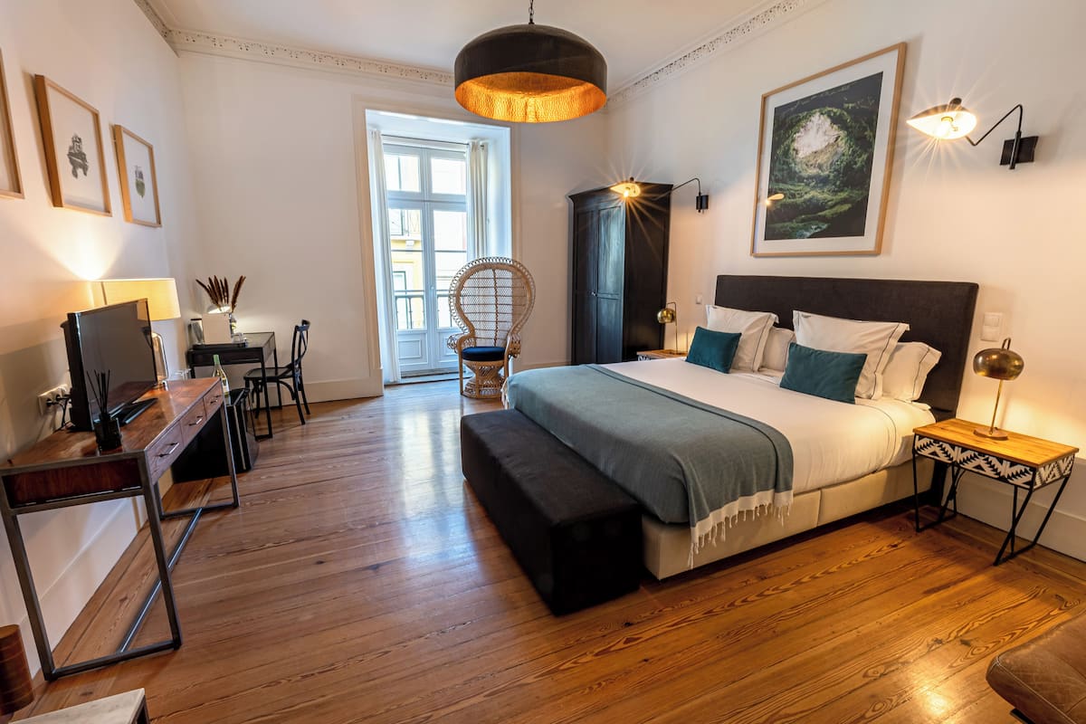 Un dormitorio con cama, mesitas de noche, escritorio y silla.