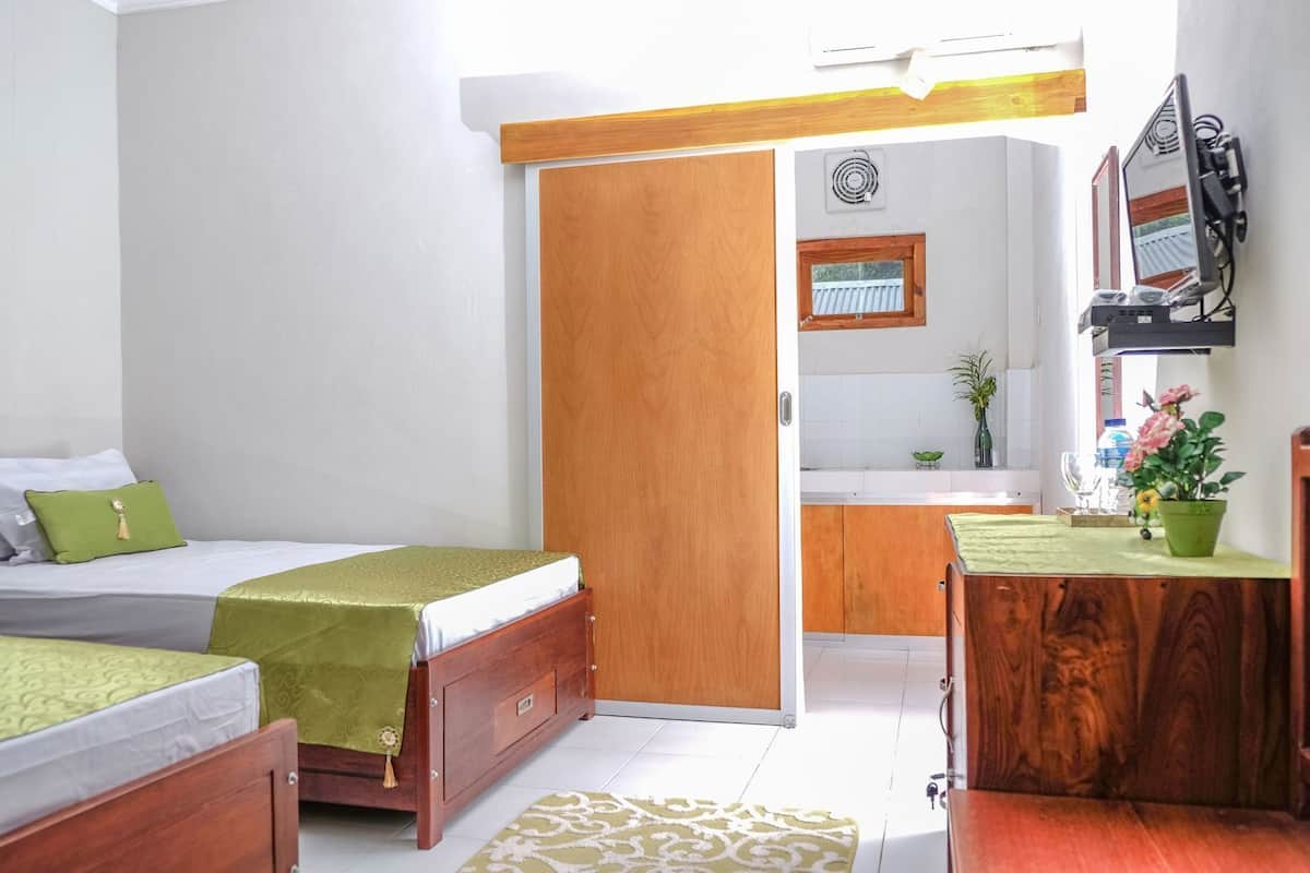 A bedroom with a bed, bedside table, and a small desk with a chair.