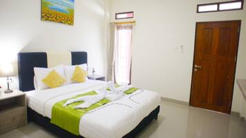 A hotel room with a bed, a nightstand, a lamp, a painting on the wall, a window with curtains, and a door.