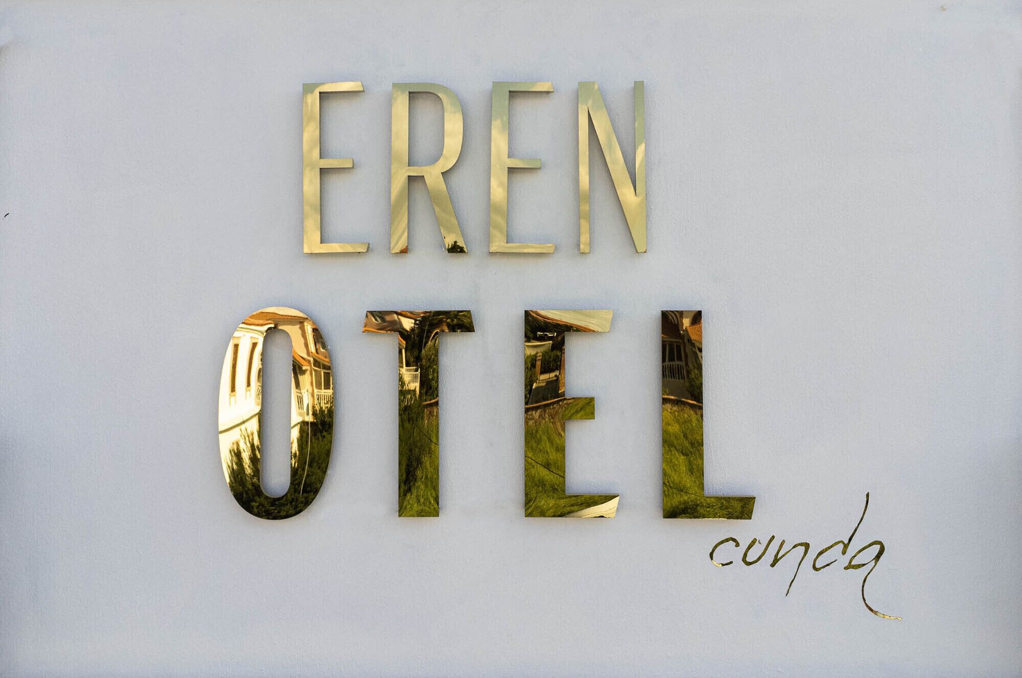 Une enseigne portant les mots « EREN HOTEL » et « cunda », écrits dans une police de caractères stylisée.