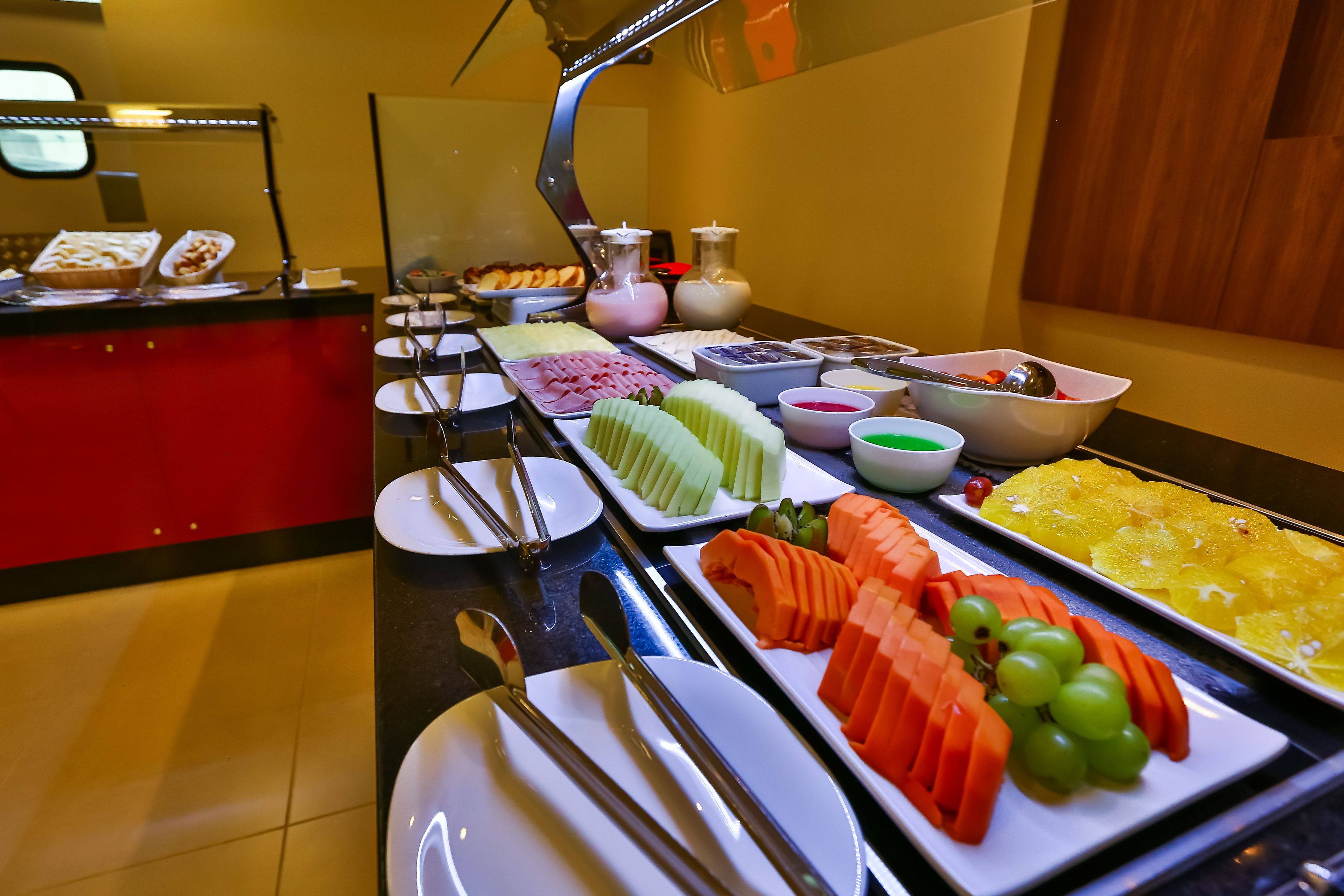 A buffet with various food items including fruits, vegetables, and meats.