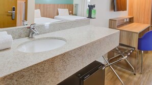 A modern hotel bathroom with a large sink, mirror, and a compact toilet. - Transamerica Fit Campinas (Campinas)