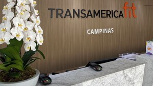 A reception desk with a sign reading "TRANSAMERICAit CAMPINAS". - Transamerica Fit Campinas (Campinas)