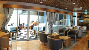 Un hall de hotel con piso a cuadros, muebles de madera y una pantalla de televisión.