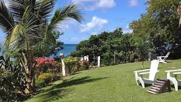 Relax in a serene outdoor space surrounded by lush greenery and a tranquil body of water.