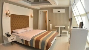 Ein modernes Schlafzimmer mit einem großen Bett, einem Nachttisch und einer kleinen Schreibtischzeile.