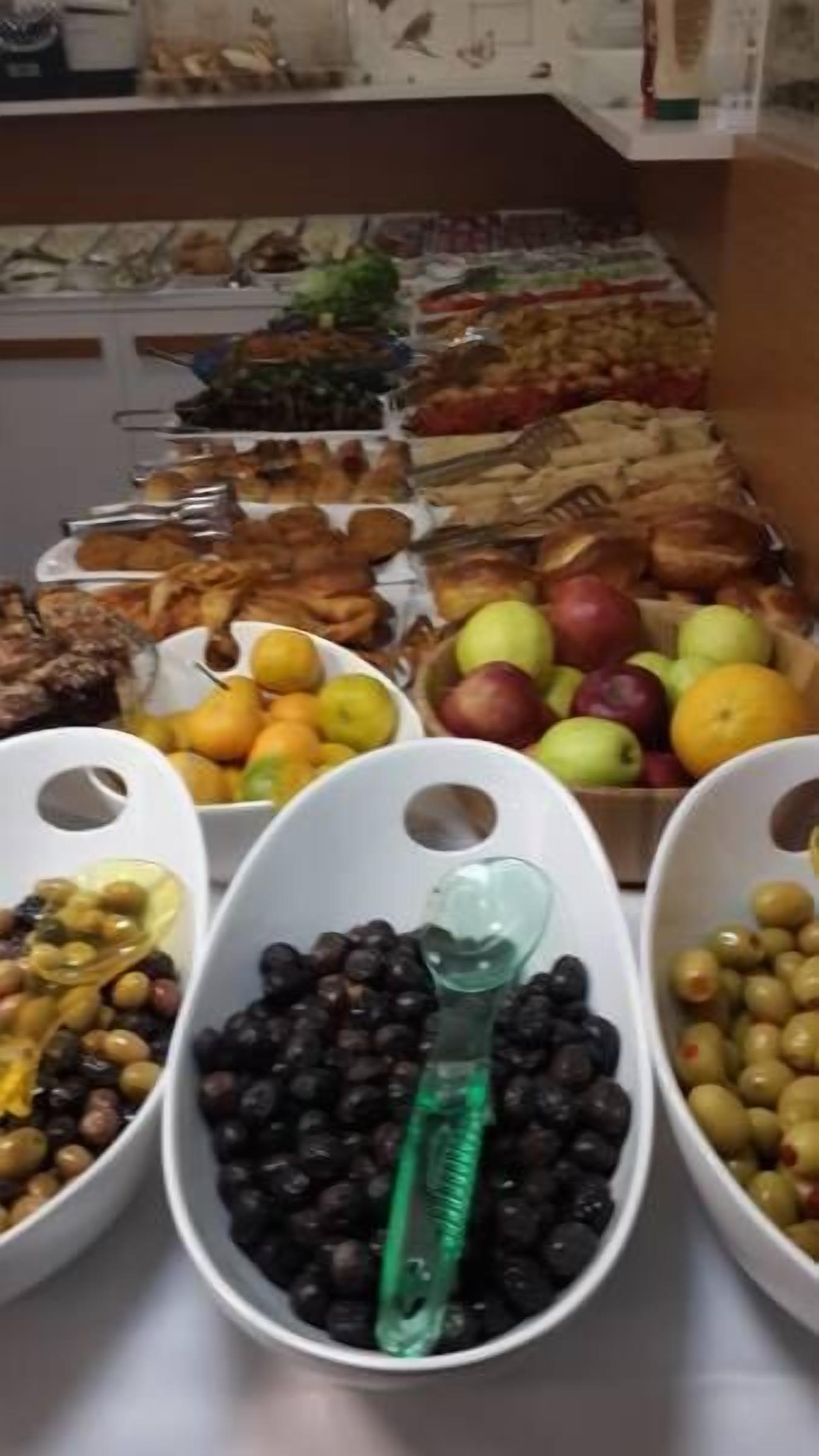 A buffet with various food items including fruits, vegetables, and meats.