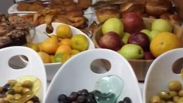 A buffet with various food items including fruits, vegetables, and meats.