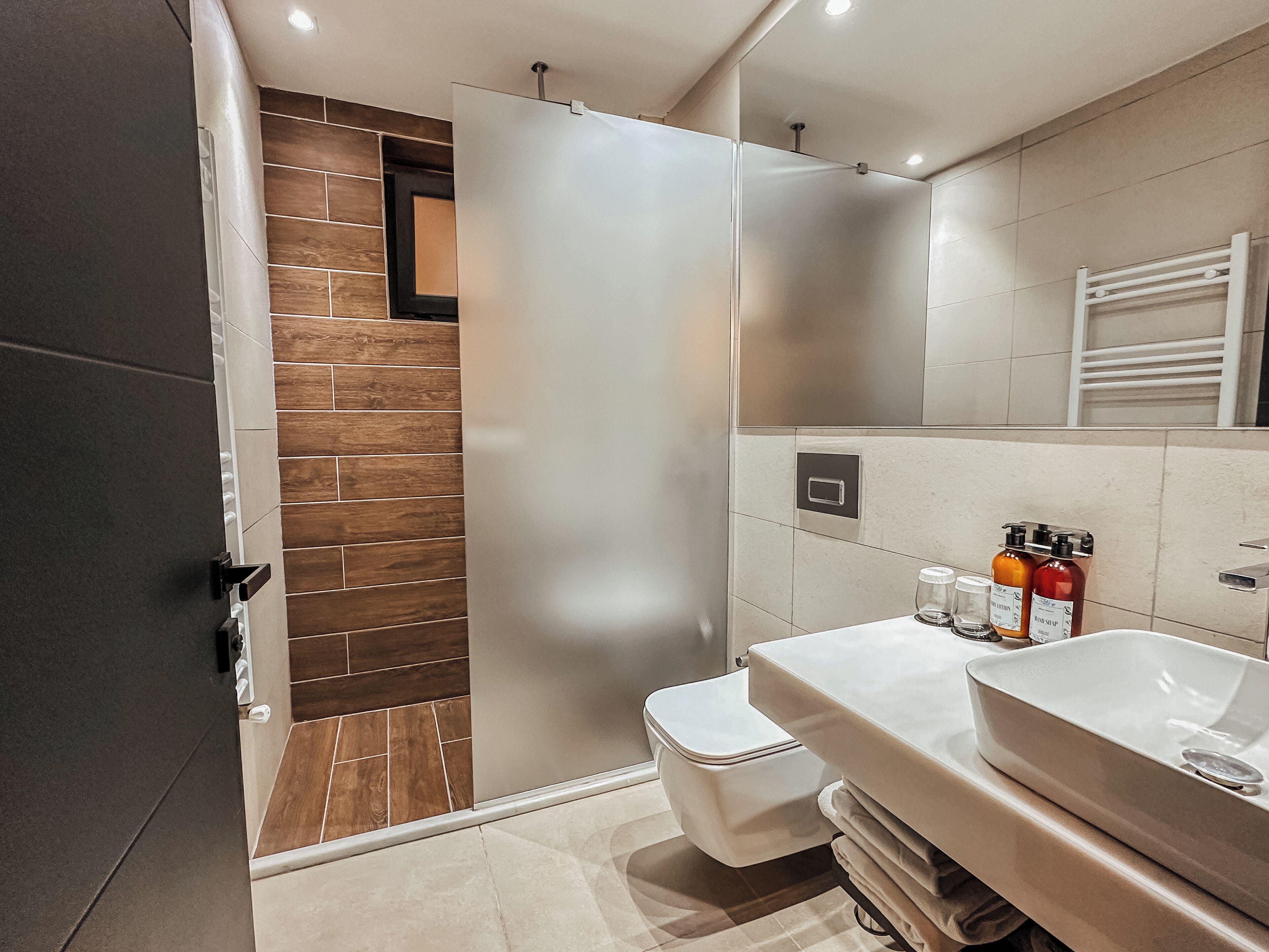 Une salle de bain moderne équipée d’une douche, de toilettes et d’un lavabo avec des produits de toilette.