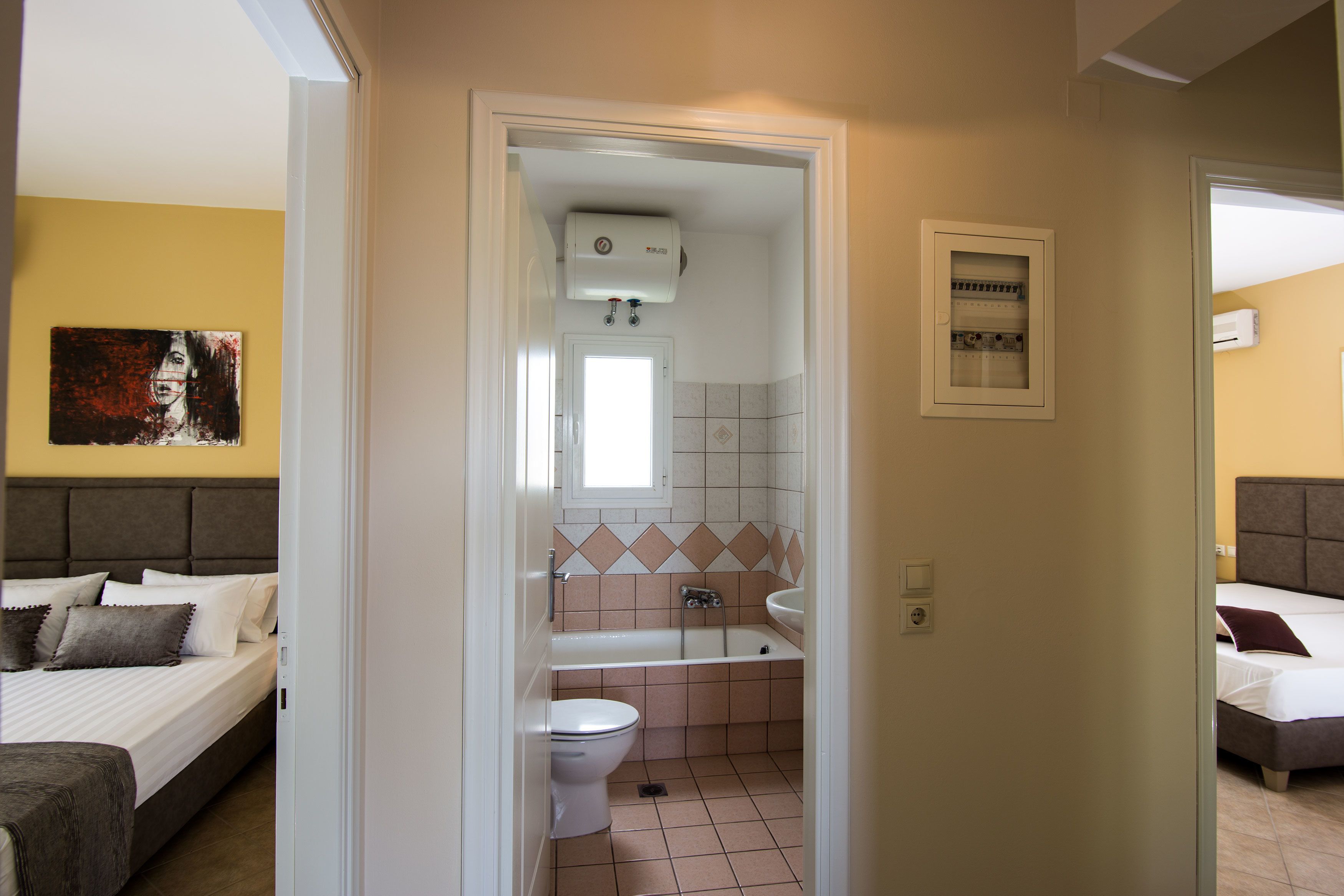 A hotel room with a bed, a bathroom with a bathtub, a toilet, and a sink.