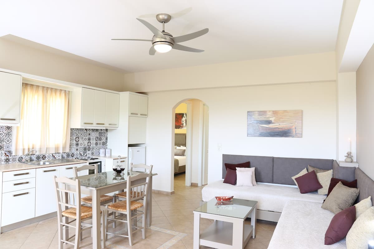 A modern apartment with a dining area, kitchen, and living room.