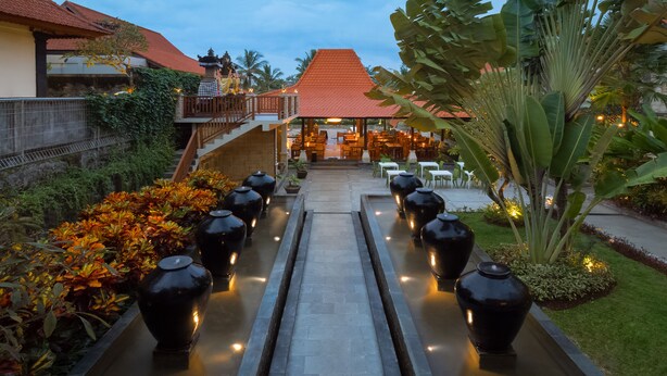 A pathway leading to a restaurant with a red roof, surrounded by greenery and decorative vases. - Best Western Premier Agung Resort Ubud (Ubud)