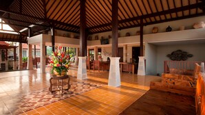 A spacious lobby with a tiled floor, wooden furniture, and a decorative plant centerpiece. - Best Western Premier Agung Resort Ubud (Ubud)