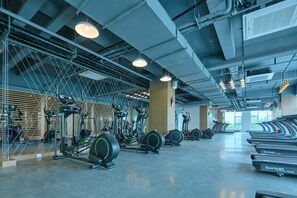 A gym with various exercise equipment, including treadmills and elliptical machines, arranged in rows. - Holiday Inn Express Luoyang Yichuan by IHG (Luoyang)