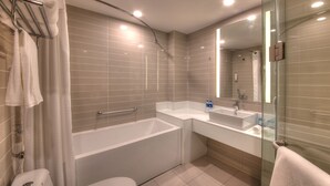 A modern bathroom with a bathtub, a toilet, a sink, and a glass shower enclosure. - Holiday Inn Express Luoyang Yichuan by IHG (Luoyang)