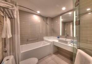 A modern bathroom with a bathtub, a toilet, a sink, and a glass shower enclosure. - Holiday Inn Express Luoyang Yichuan by IHG (Luoyang)