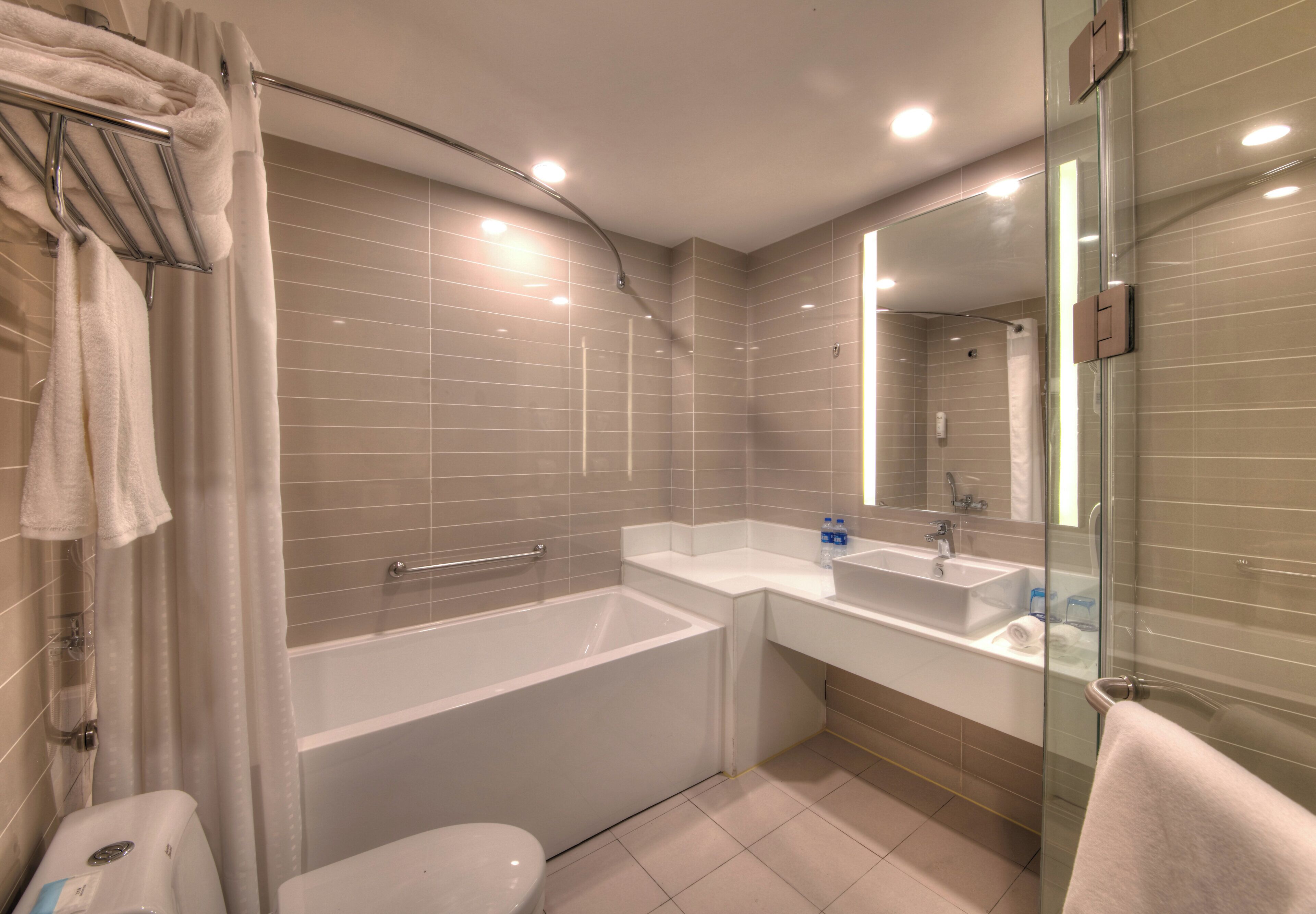 A modern bathroom with a bathtub, a shower, a toilet, and a sink.