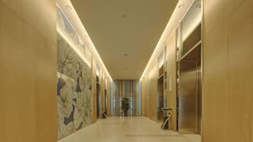 A hallway with a polished floor, wooden walls, and a floral mural.