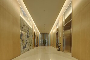 A hallway with a polished floor, wooden walls, and a floral mural. - Holiday Inn Express Luoyang Yichuan by IHG (Luoyang)