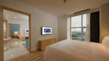 Una habitación de hotel con cama, ventana con vistas, televisión y escritorio con silla.