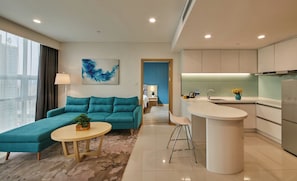 Una sala de estar moderna con un sofá, una mesita redonda y una cocina con barra.